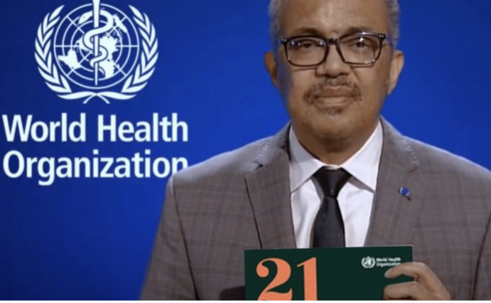 Screen capture of the director-general of W.H.O. He is holding a copy of the road map.