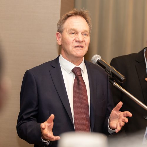 photo of a man named Mark Bradley wearing a suit and tie speaking at a podium. 