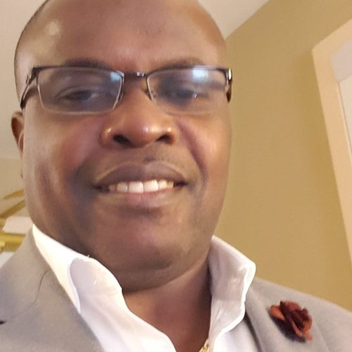 photo of a man wearing glasses and a tan suit