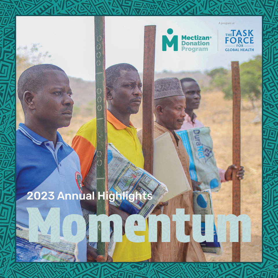 Four community drug distributors stand in a rural setting, each holding campaign materials and a dose pole. The text on the image reads "Momentum. 2023 Annual Highlights" along with logos for "Mectizan Donation Program" and "The Task Force for Global Health.